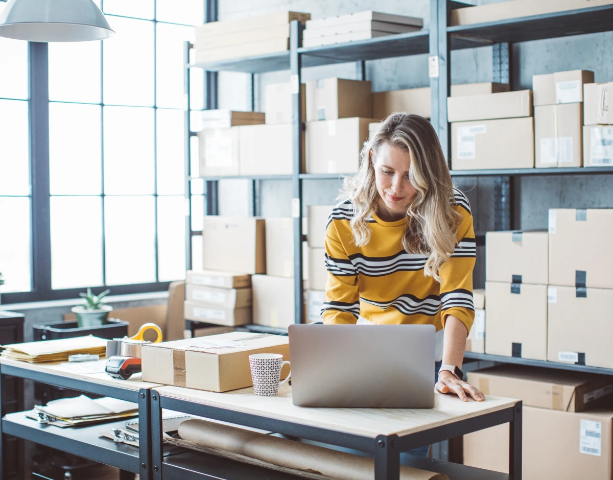 Mature woman at online shop. She is owner of small online shop. Receiving orders and packing boxes for delivery.