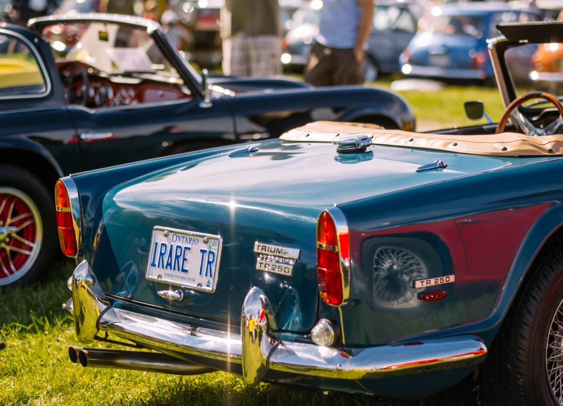 Burlington, Ontario, Canada - September 20, 2015. Rear view of sporty vintage British cars. People in the background. British Car Day is a classic car show hosted annually by the Toronto Triumph Club at one of the public Parks (Bronte Park) in Burlington (suburbs of Toronto), on the third Sunday of September. Since its inaugural event in 1984, it has grown in leaps and bounds, and now draws over 1,000 British cars and 8,000 spectators, with room to grow even bigger. British Car Day is open to vintage, classic and current British manufactured vehicles, including motorcycles.