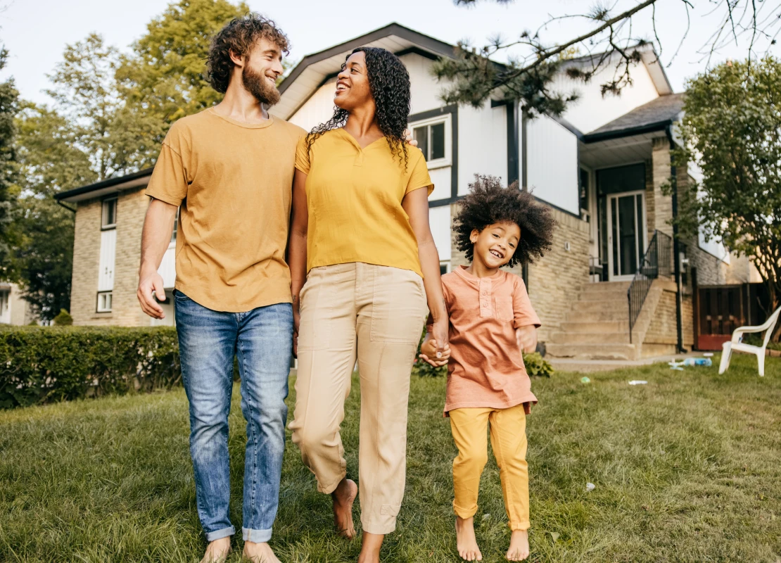 family happily together in front of their homes