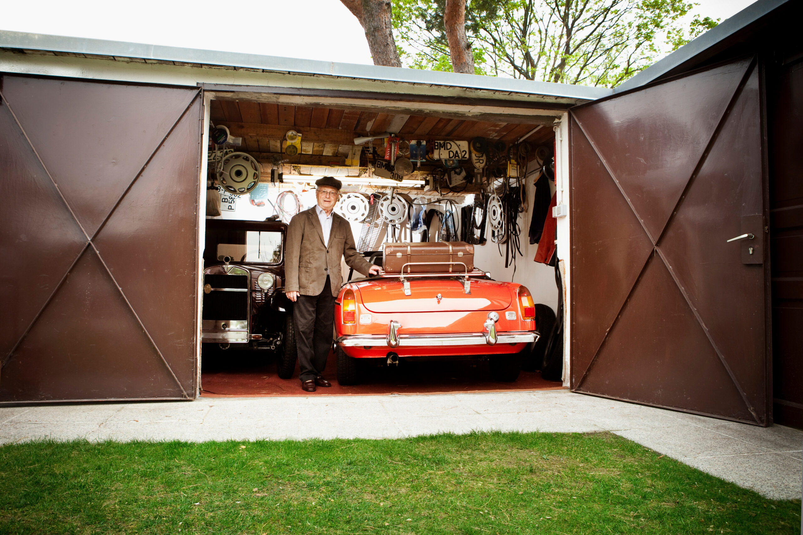 Senior man with vintage car in garage